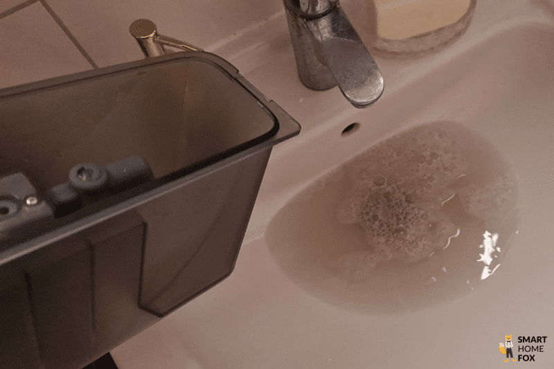 Der Schmutzwassertank der Yeedi Cube OMNI-Station wird in der Toilette ausgeleert.